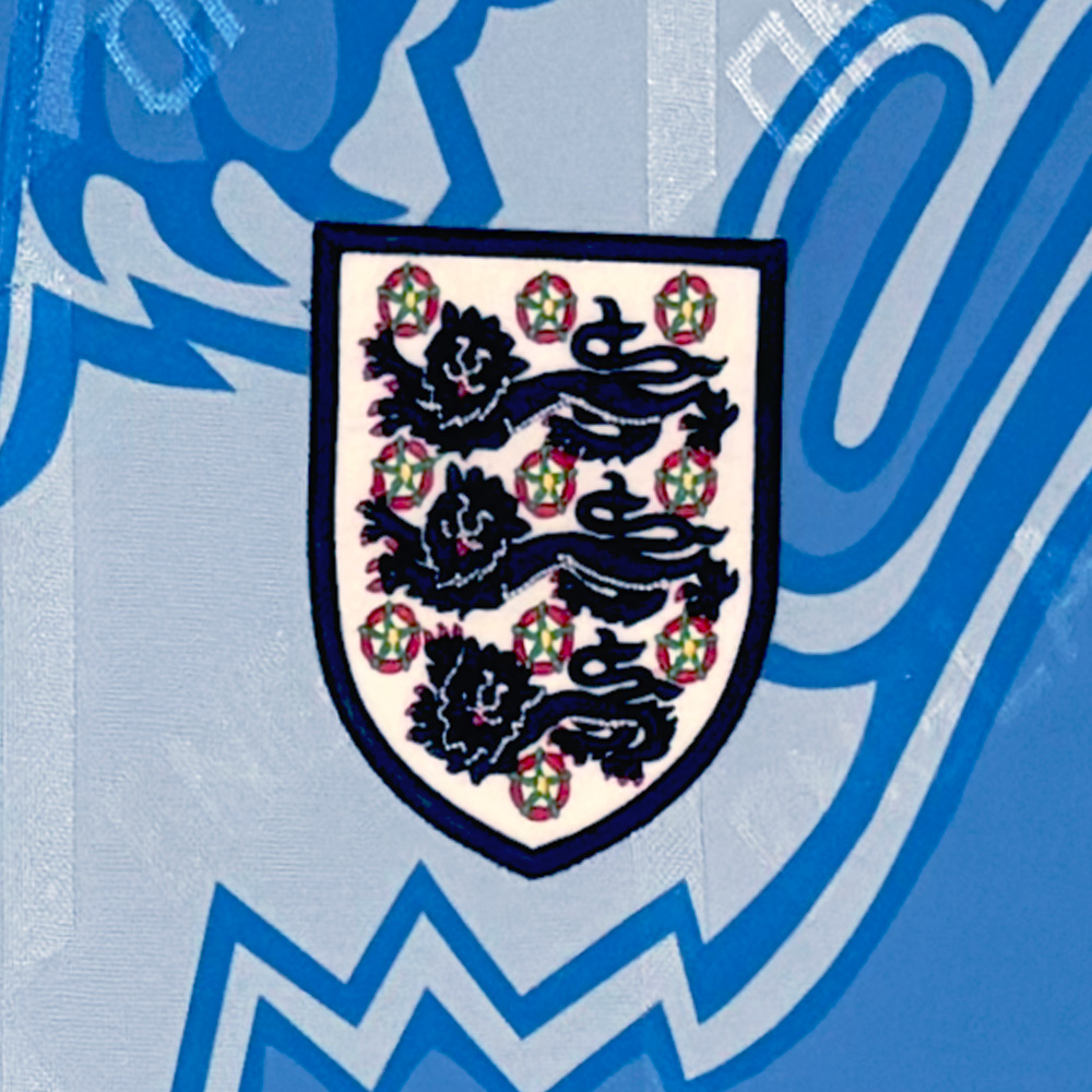 The emblem of the England football team featuring three lions and roses on a blue background.