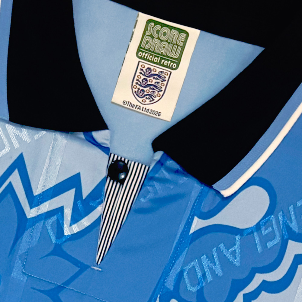 Close-up of a blue retro football shirt collar with a button and striped detail, featuring a tag labeled 'Score Draw Official Retro'.
