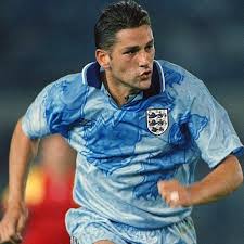 A soccer player in an England kit sprinting on the field.